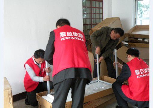 行銷組李家暉總監(jiān)(右一)、家具上海事業(yè)部閘北責任中心楊侃經(jīng)理(左二)、崇明縣新河鎮(zhèn)民政辦秦衛(wèi)明主任(右二)一起動手參與組裝辦公桌，大家熱情高漲